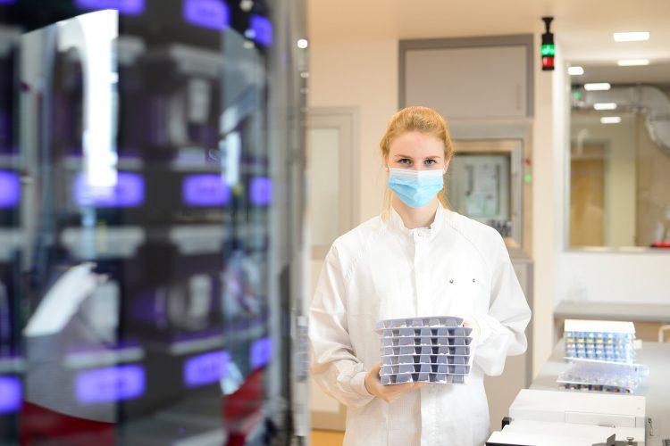 Mitarbeiterin des Blisterzentrums hält einen Stapel Blisterkarten in den Händen
